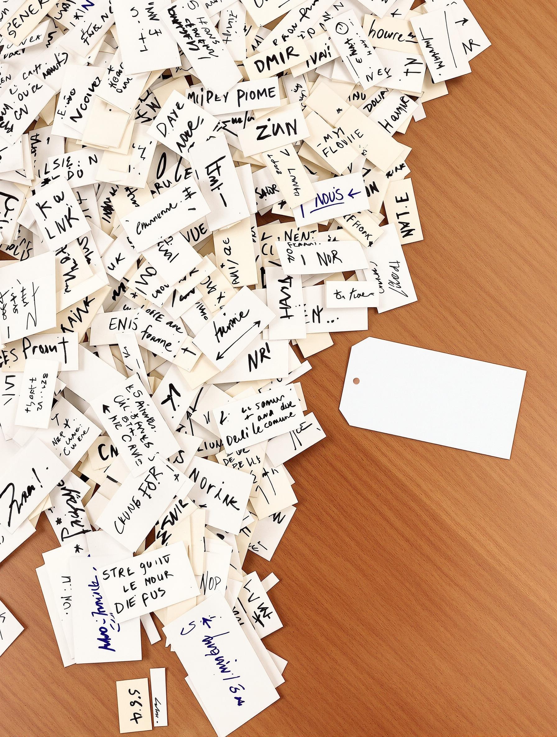Une pile d'étiquettes manuscrites désordonnées face à une étiquette imprimée professionnelle.